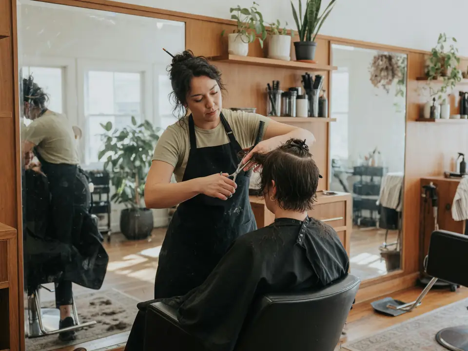Kapster knipt een klant in de salon